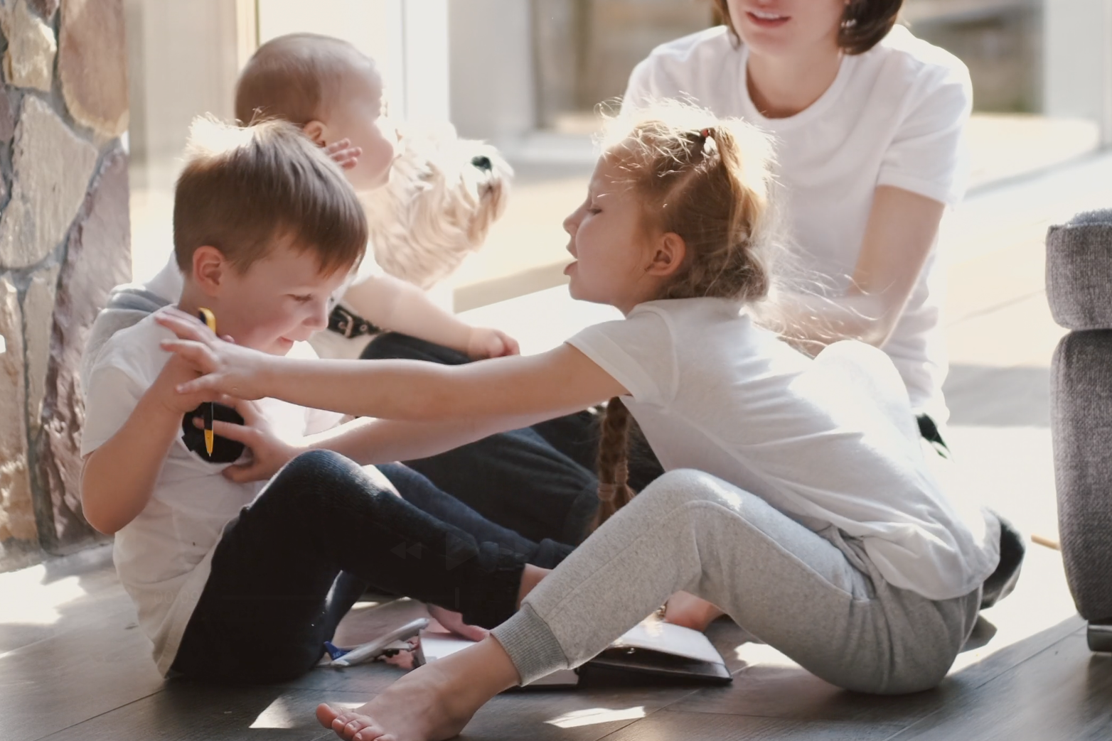 Zwei Kinder streiten sich im Kinderzimmer, eines zieht an einem Spielzeug, das andere hält dagegen. Typischer Geschwisterstreit im Familienalltag.